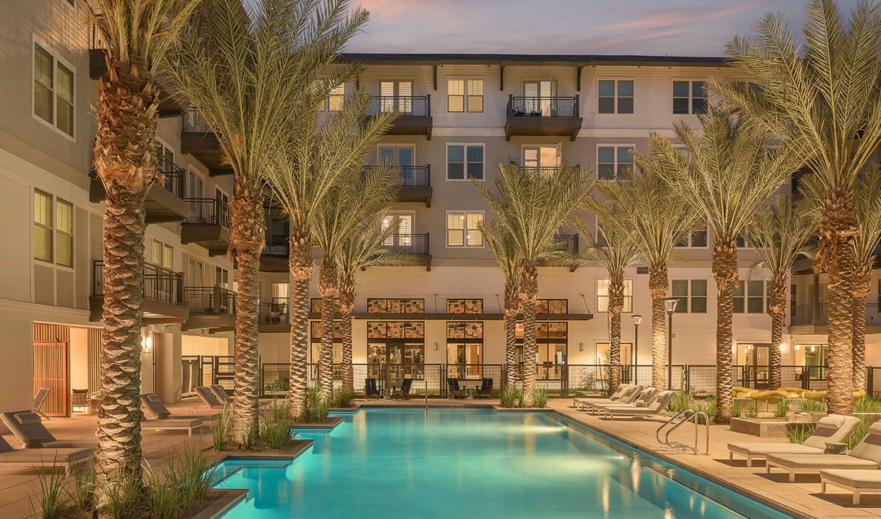Find Your New Home At The Tyler large resort style pool with chairs and palm trees